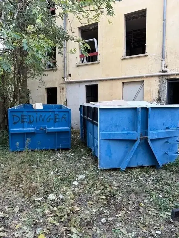 Deux bennes JDM posées dans la cour d'un immeuble en travaux